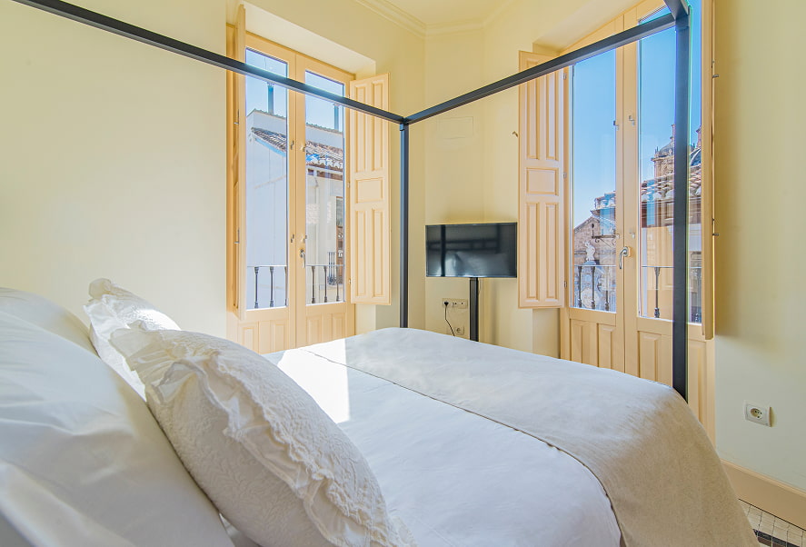 Habitación con cama doble con dosel y vistas a la ciudad
